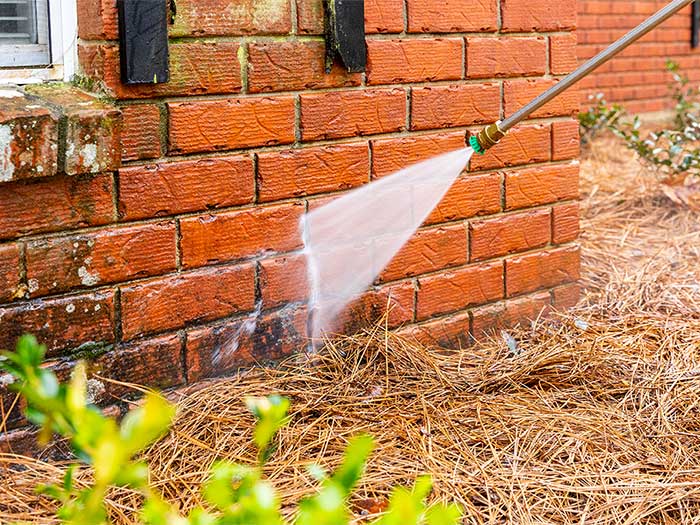 Person washing brick house